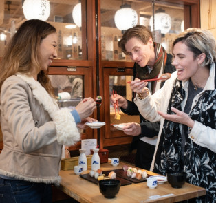 Local host and travelers enjoying sushi in Tokyo