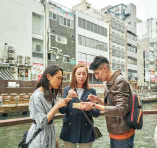 People eating street food in Osaka, Japan