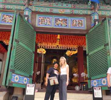 Standing before vibrant temple doors in sunny Seoul.