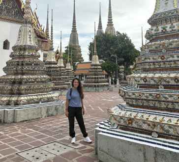 Strolling through intricate stupas under Bangkok's expansive sky.