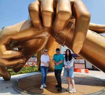 Golden Moments: Striking a Pose Under Giant Hands