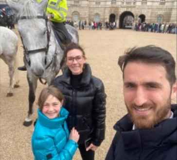 Smiling together with a horse guard on a cloudy London day.