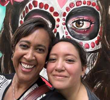 Sharing smiles in front of vibrant Mexico City street art.