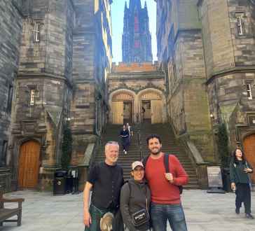 Pausing for a cheerful photo under Edinburgh's striking architecture.
