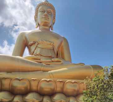 Tourists photographing the huge Buddha statue at Wat Muang.