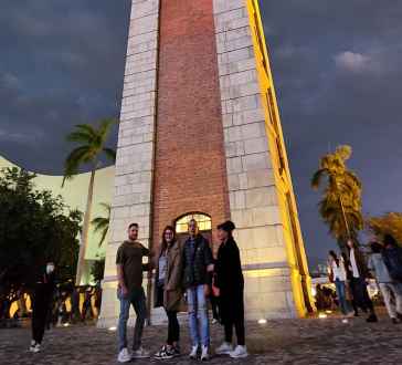 Clock tower at night with clouds in the background.