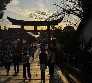 People walking through a torii gate at Fushimi Inari Shrine, Kyoto, Japan.
