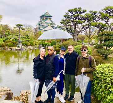 A rainy day adds charm to exploring Osaka Castle's gardens.