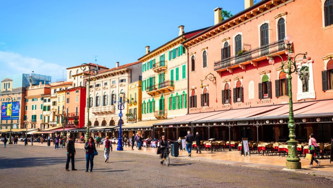 building,city,town,urban area,public space,facade,pedestrian,street,town square,human settlement,mixed-use,metropolitan area,tourist attraction,vacation,travel,leisure,plaza,holiday,awning,crowd,walking