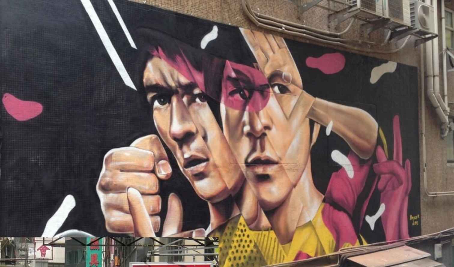 Mural of martial artists on a building wall in Hong Kong.