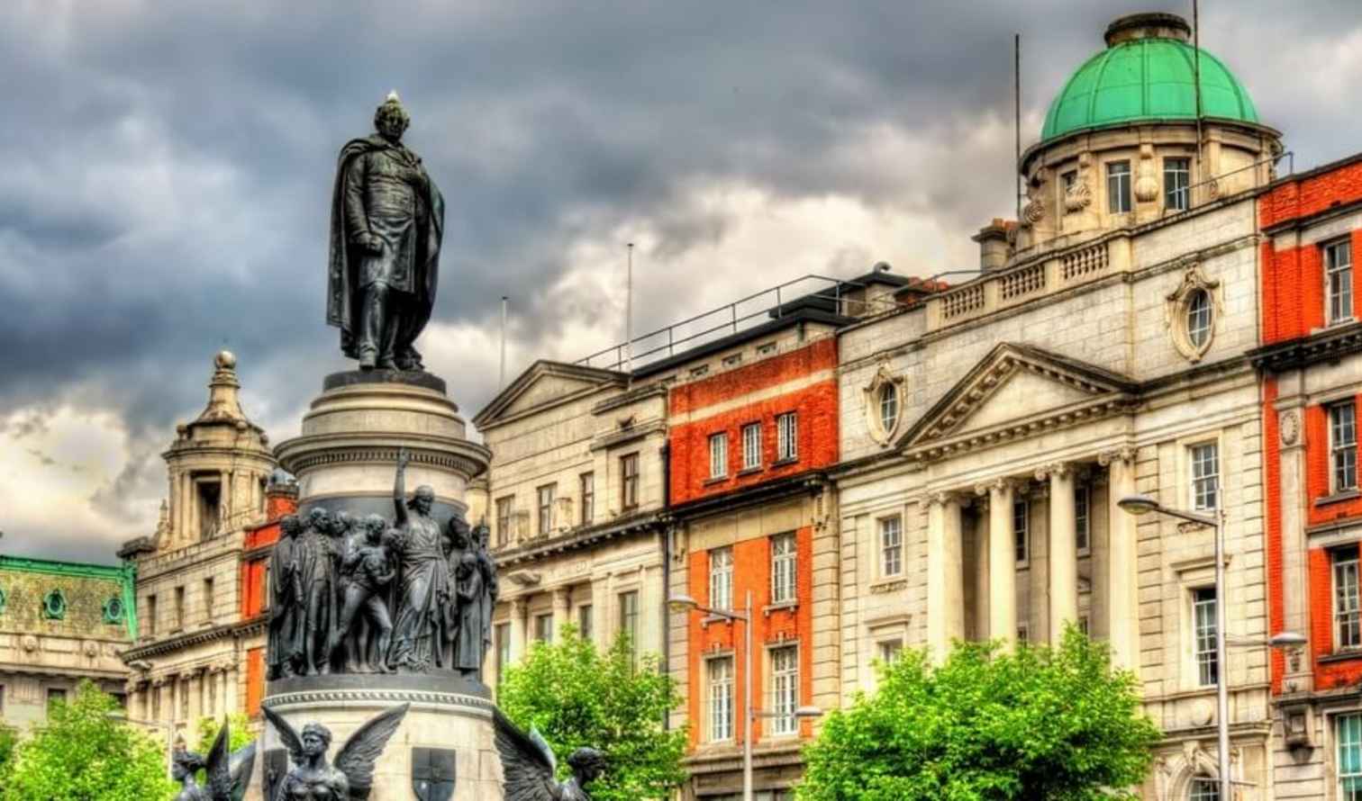 Statue of Daniel O'Connell on O'Connell Street, Dublin with historic buildings in view.