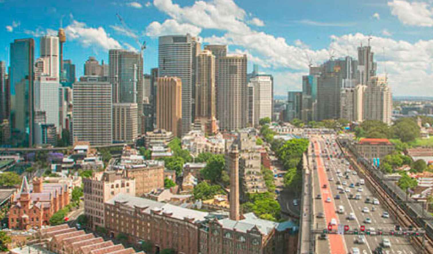 Skyline of Sydney with tall buildings and the Sydney Harbour Bridge.