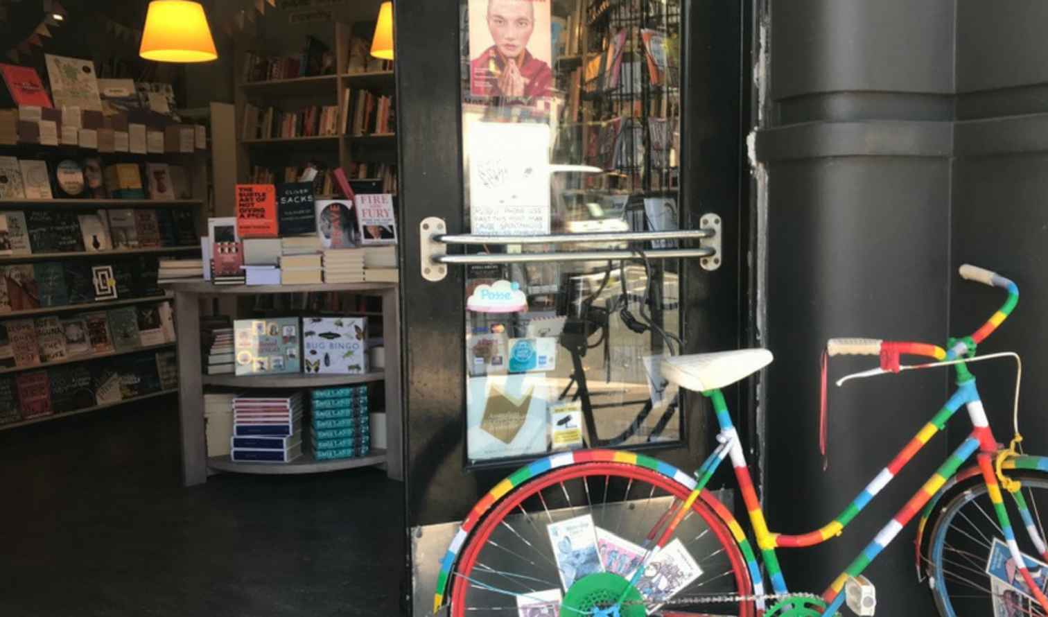 Multicolored bicycle beside a black door with book posters in Sydney