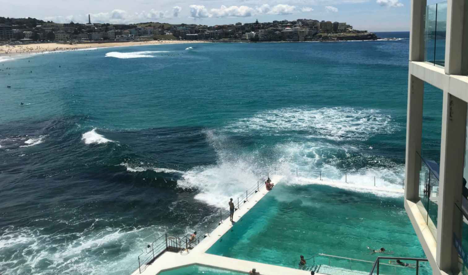 View of Bondi Beach with ocean pool in the foreground.