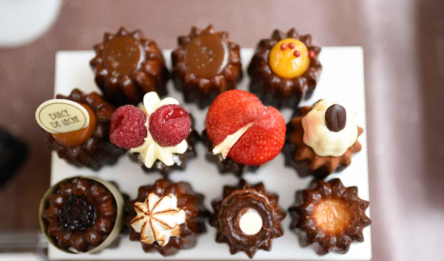 Assorted pastries with various toppings displayed on a white tray in London