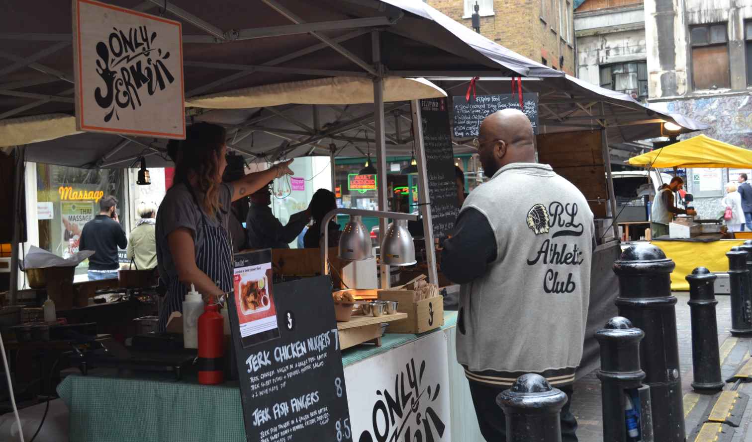 Street food stall in Camden Market, London, with customer and vendor visible.