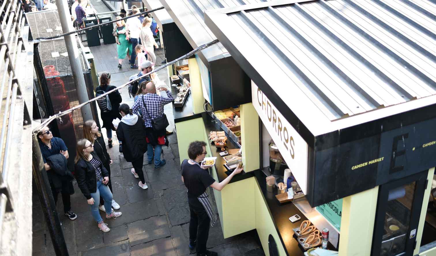 People gathered around food stalls at Camden Market, London.