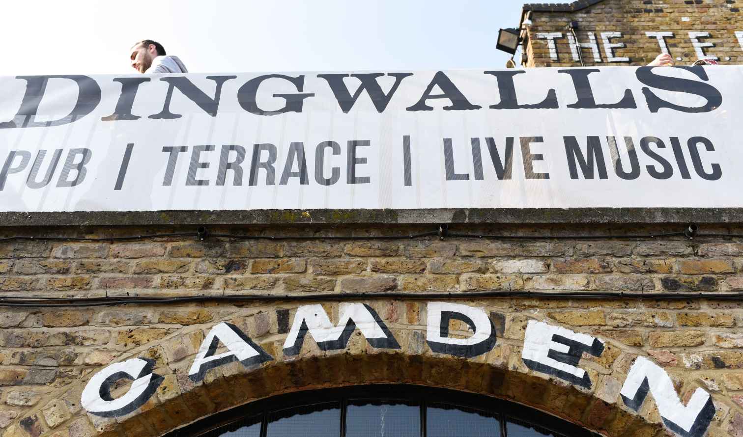 Person standing near a sign at Camden Market, London.