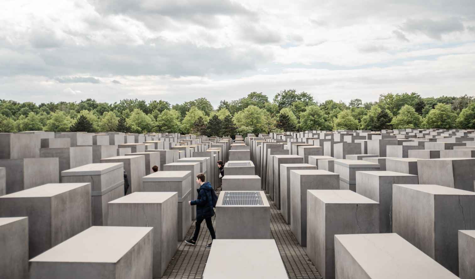 Visitors walking among concrete steles at the Memorial to the Murdered Jews of Europe, Berlin.
