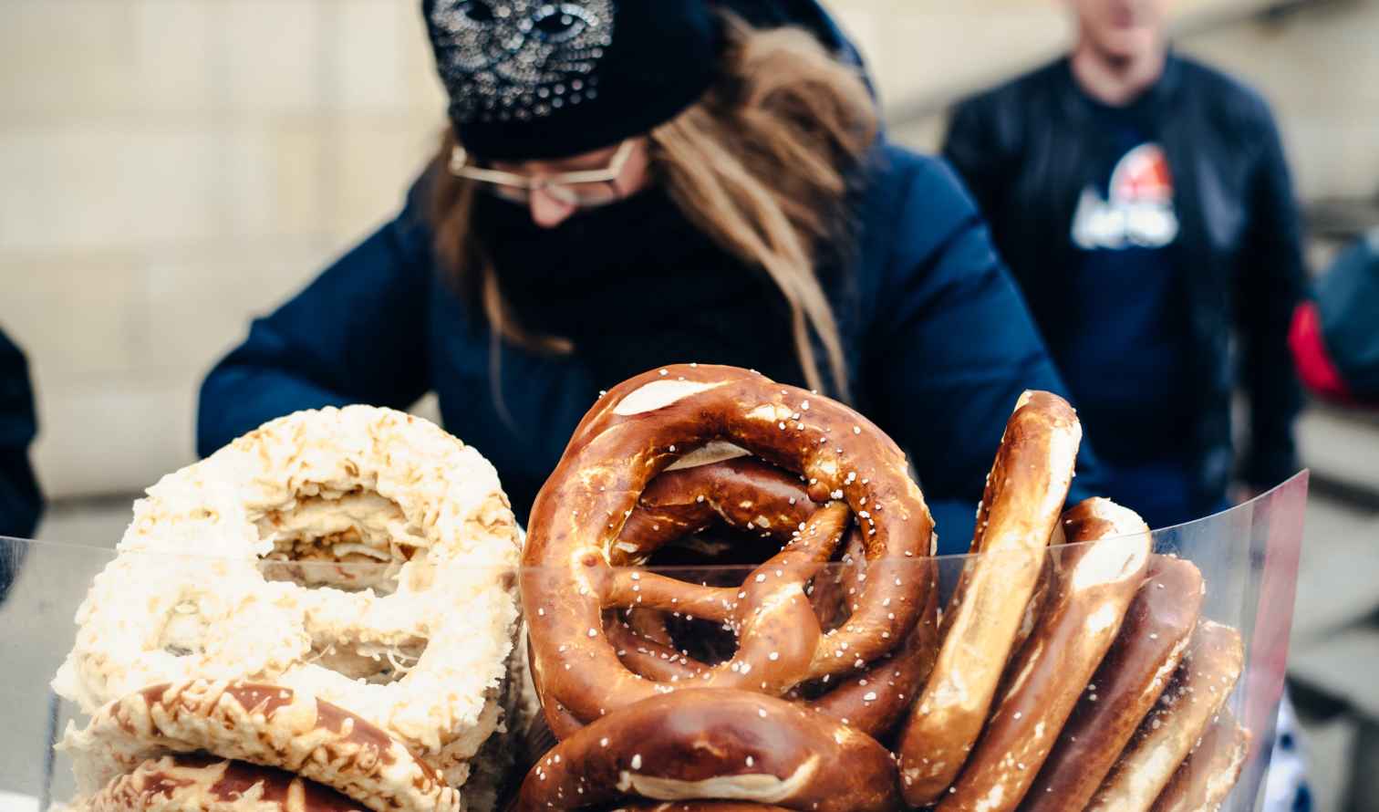 Person selling pretzels wrapped in plastic outdoors in Berlin