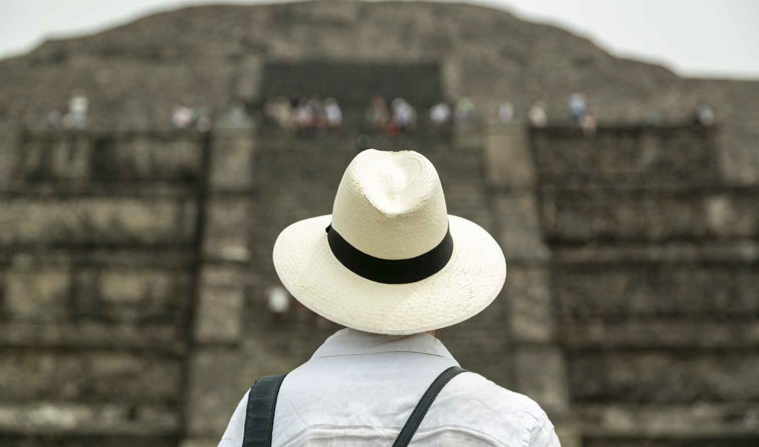 Tourist in a hat observing the Pyramid of the Sun, Teotihuacan.