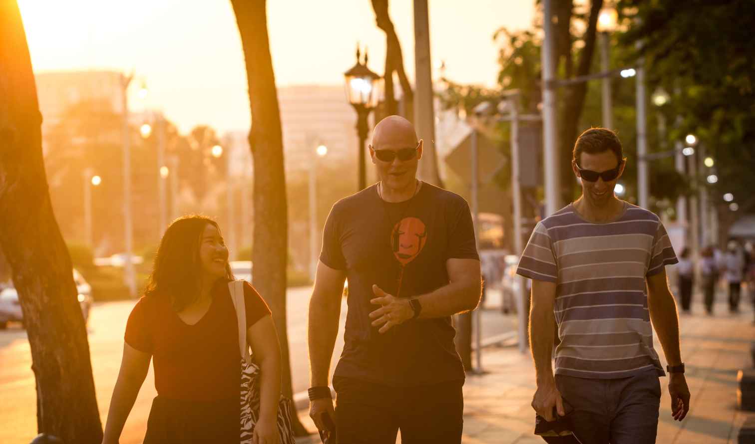 Group of friends walking along a city street in the evening in Bangkok