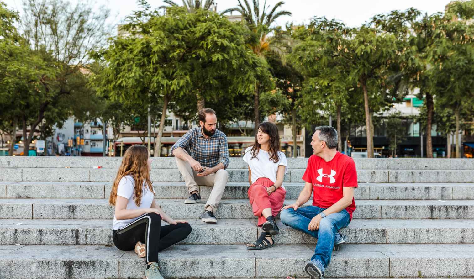Four people sitting on stone steps at Plaza de España,Barcelona