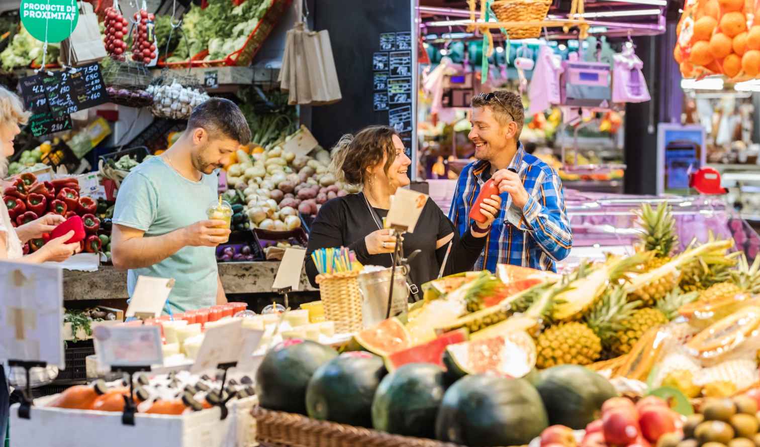 People shopping for fruits and vegetables at a market stall in Barcelona