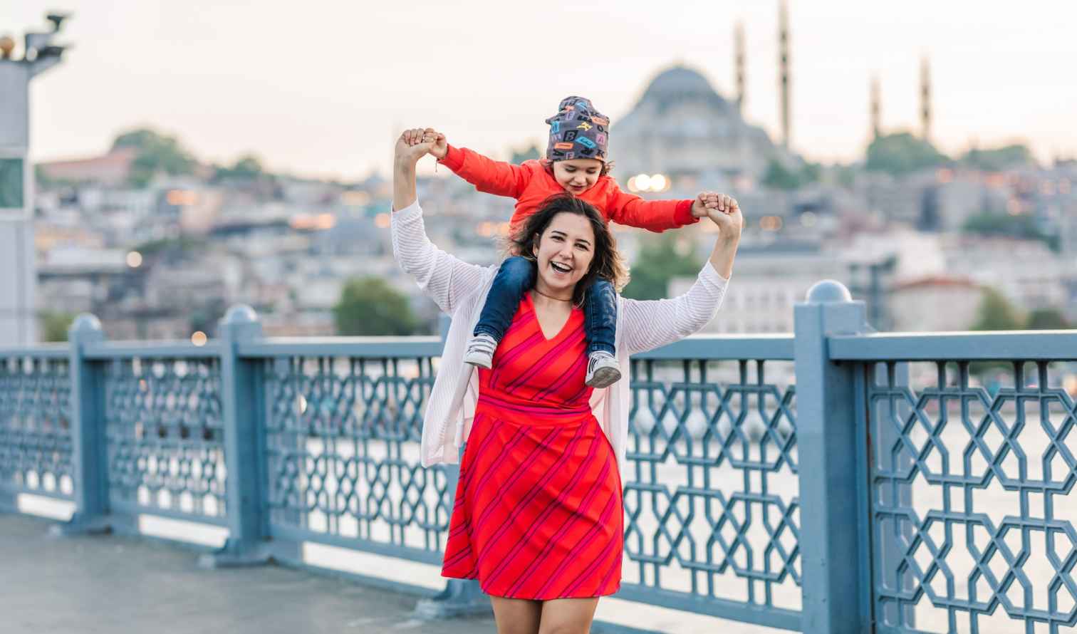 Woman carrying a child on her shoulders on Galata Bridge in Istanbul