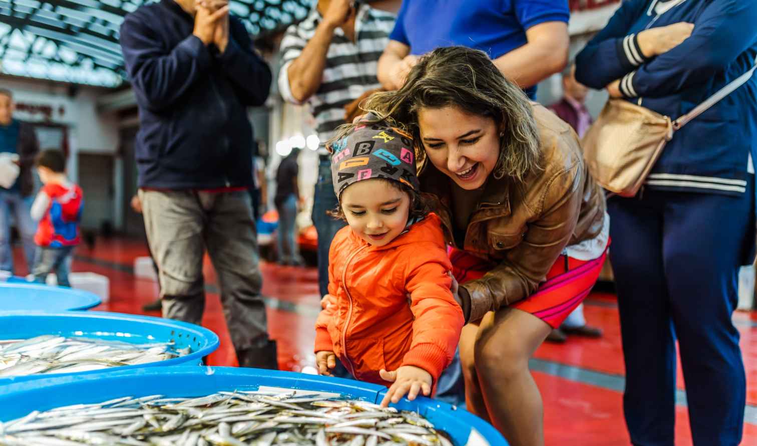 Various fish are displayed in blue tubs at a seafood stall in Istanbul