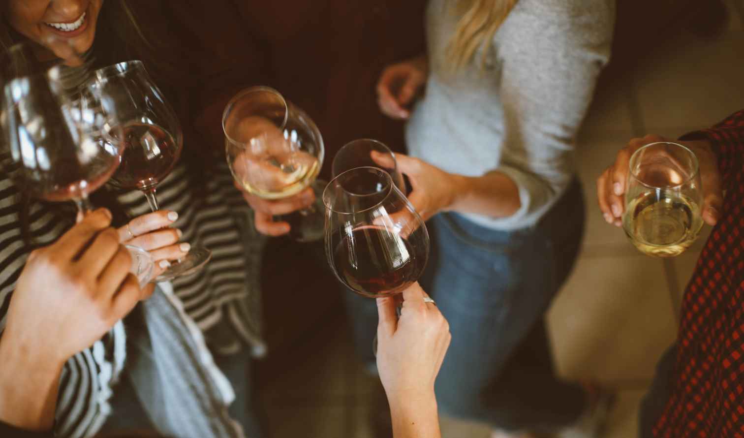 Group of hands holding wine glasses in a celebratory toast in Lisbon