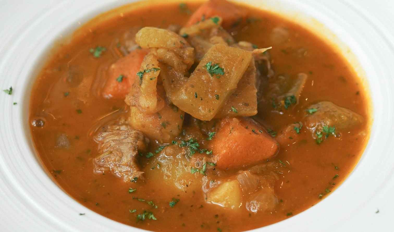 Close-up of a bowl of meat and vegetable stew on a white plate in Liverpool