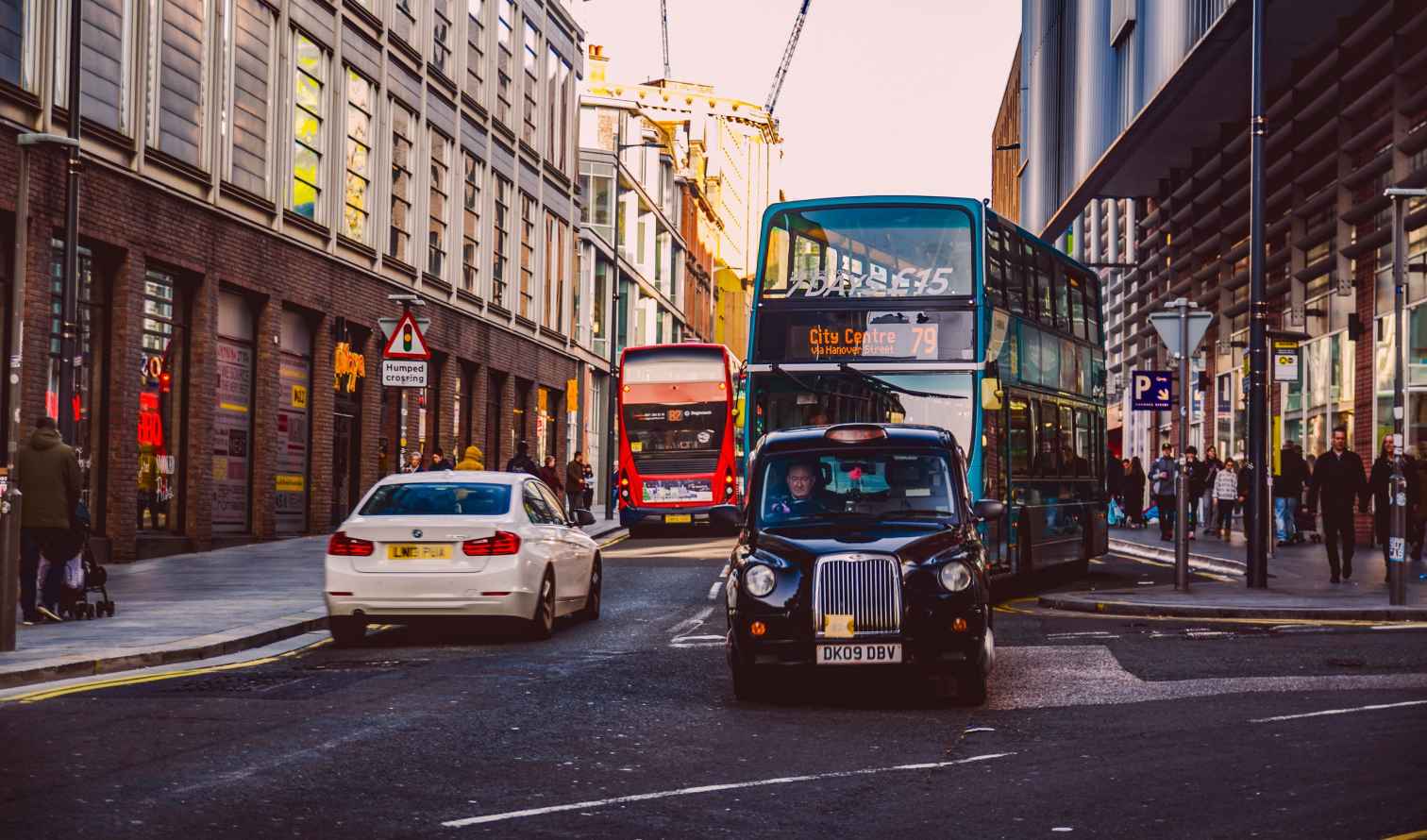 Street view of Hanover Street in Liverpool with buses and cars.