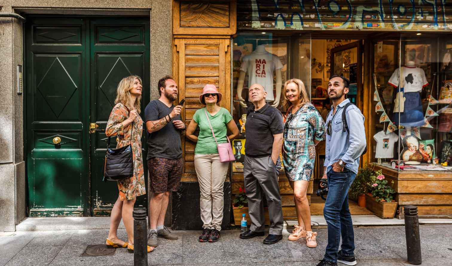 People standing outside a shop with T-shirts on display in Madrid.