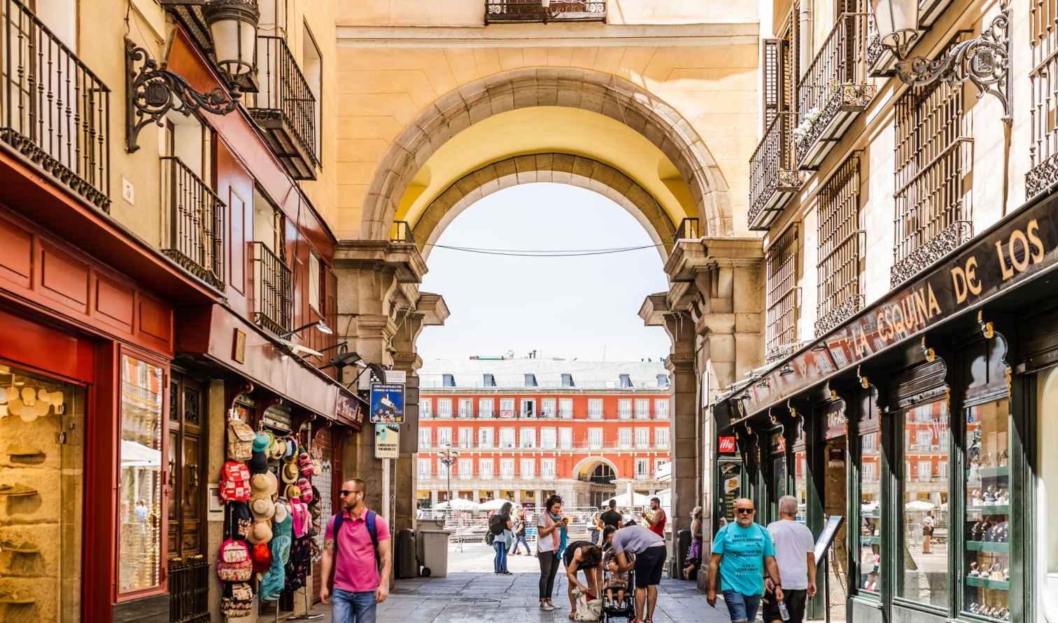 Plaza Mayor archway in Madrid, with people walking underneath.