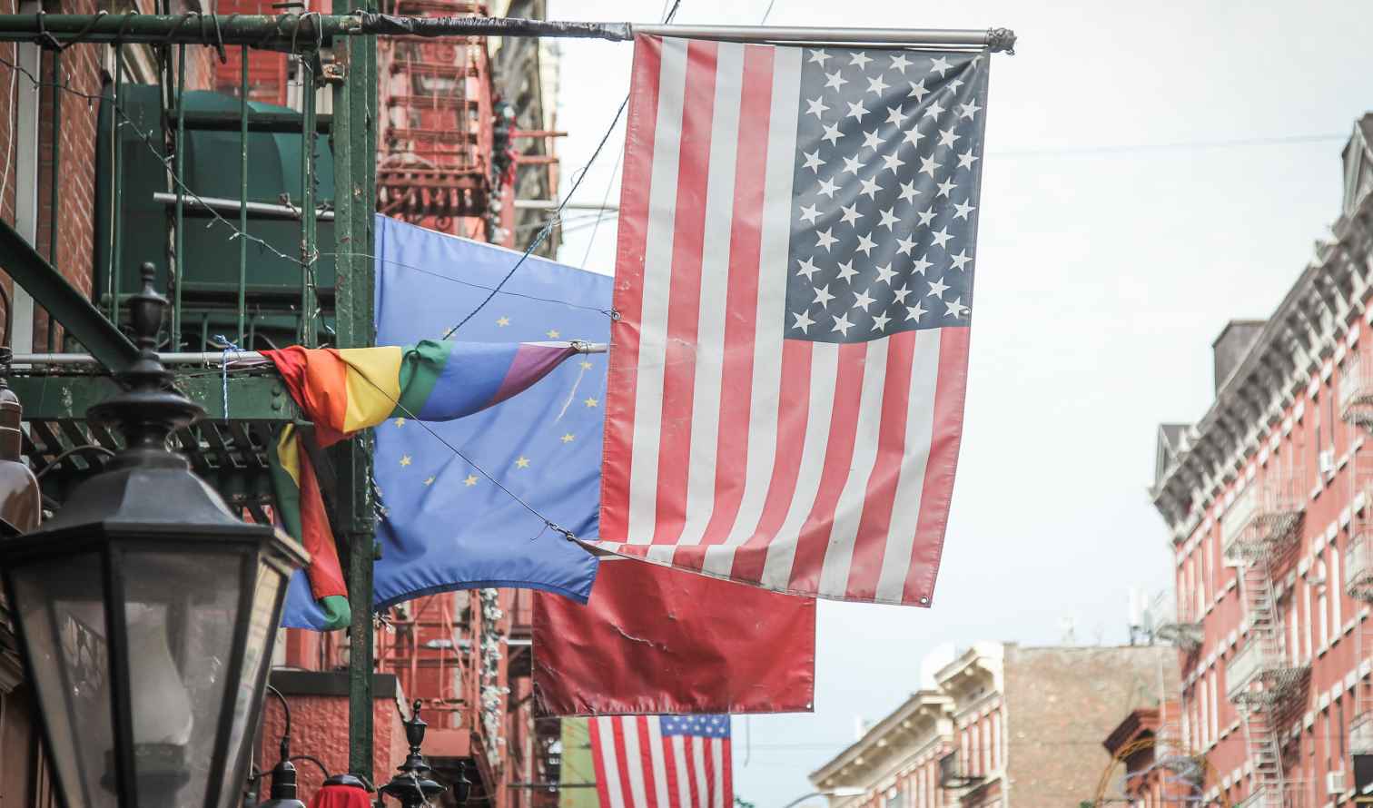 American and rainbow flags hanging on a New York City street.