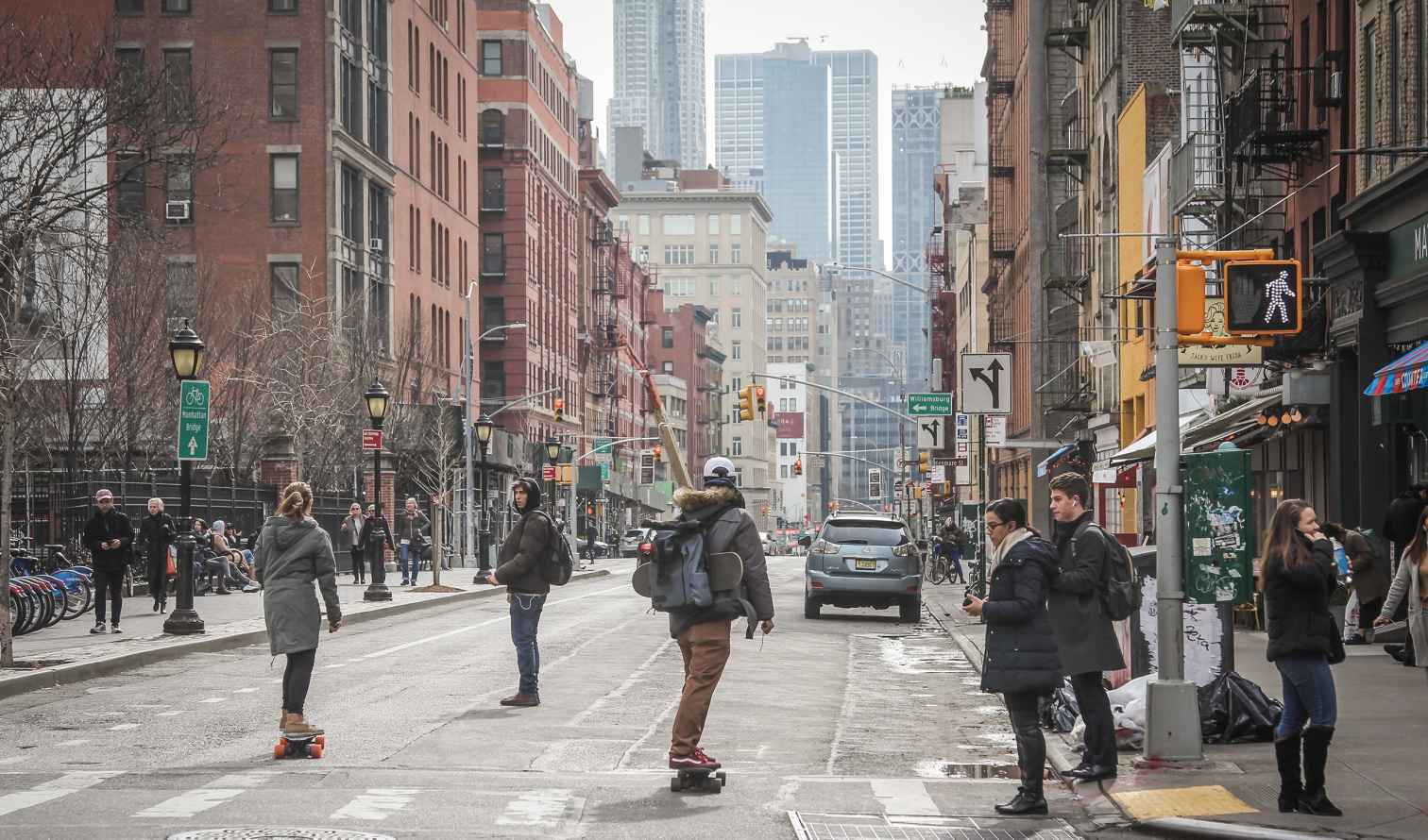 People walking and skateboarding on a street in Manhattan, New York City.