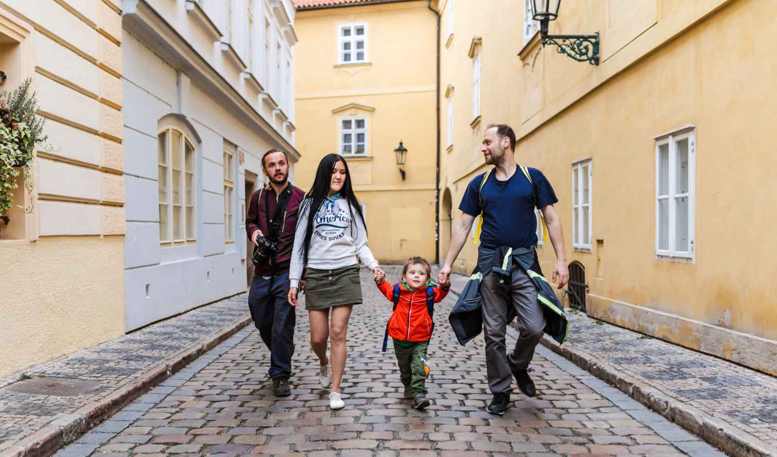 Family walking on a cobblestone street in Prague.