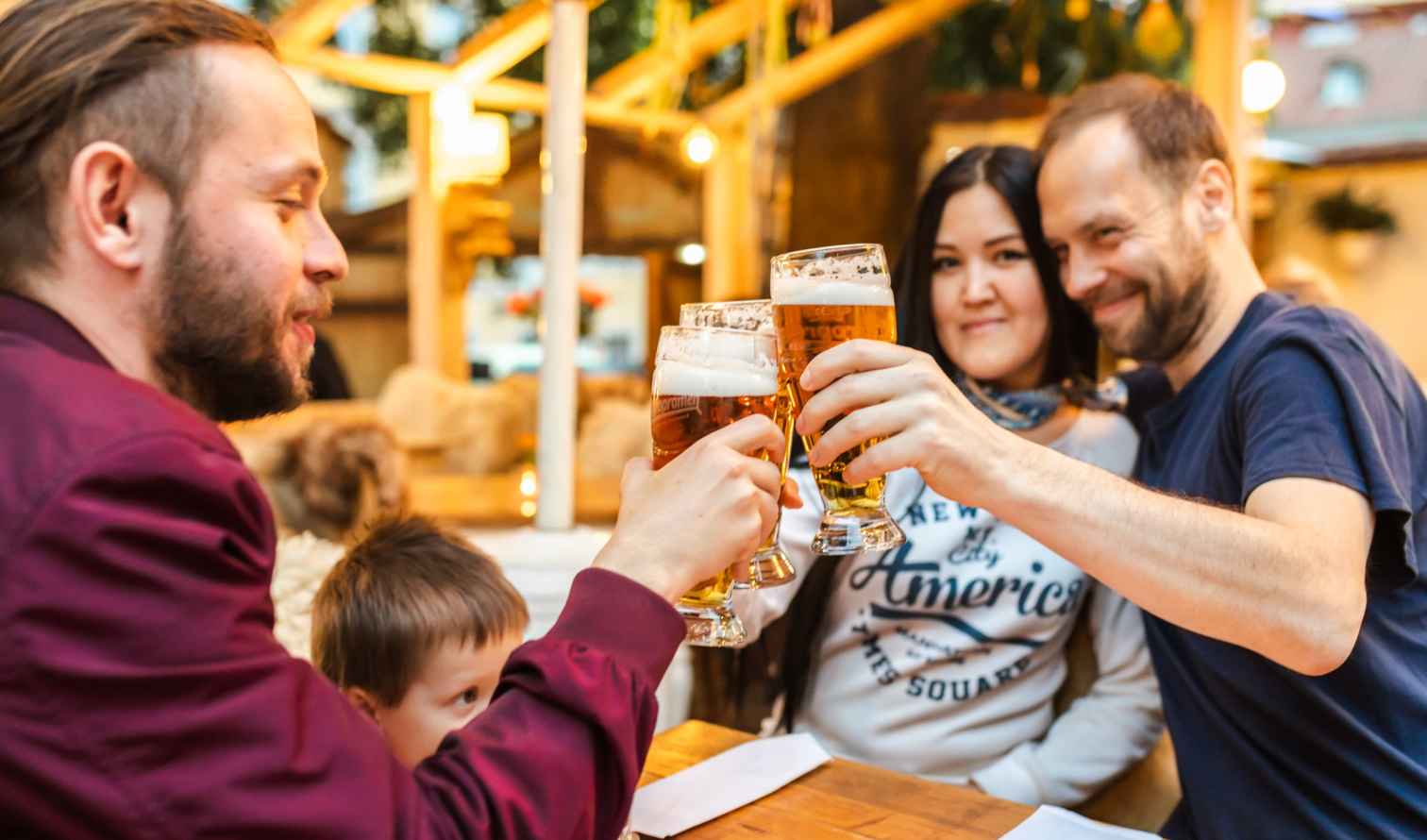 Group toasting with beer glasses at an outdoor restaurant in Prague
