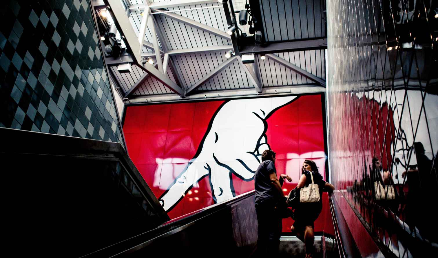 Two people on an escalator at the 14th Street subway station.