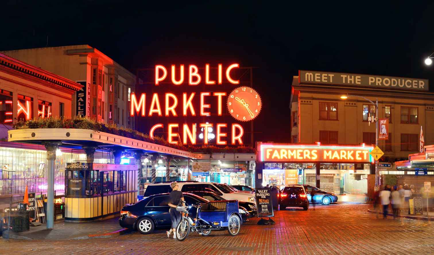 Bicyclist near Farmers Market sign in Seattle's Pike Place Market.