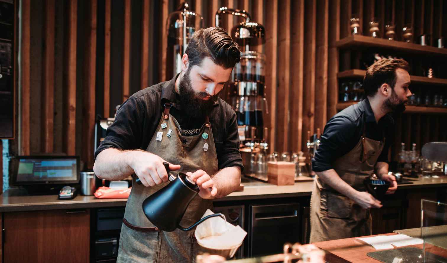 Two baristas working behind the counter in a modern coffee shop in Seattle