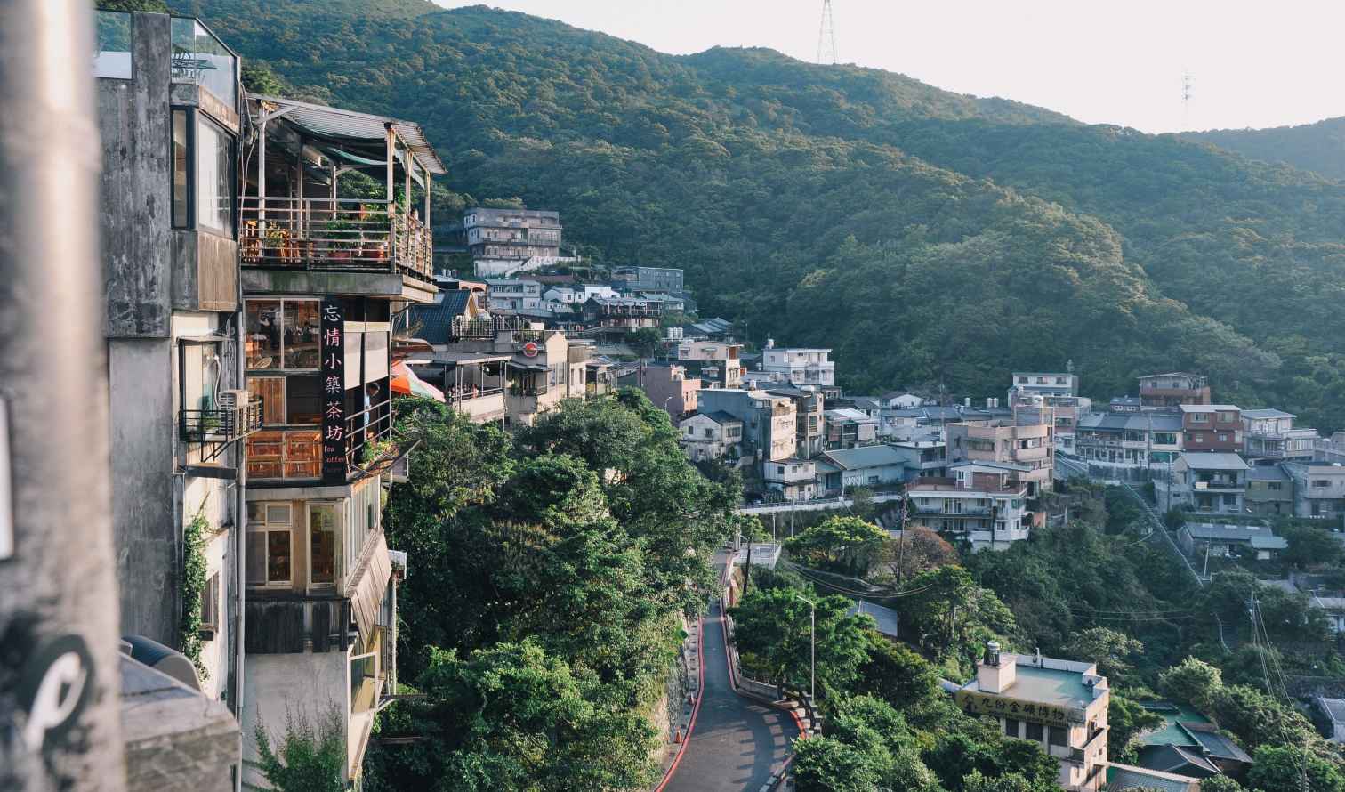Buildings on a hillside in Jiufen, Taiwan, surrounded by forested mountains.