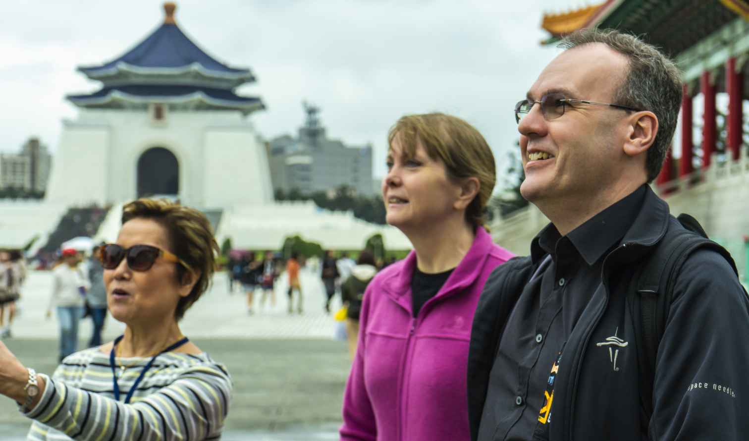Three people standing near Chiang Kai-shek Memorial Hall in Taipei.