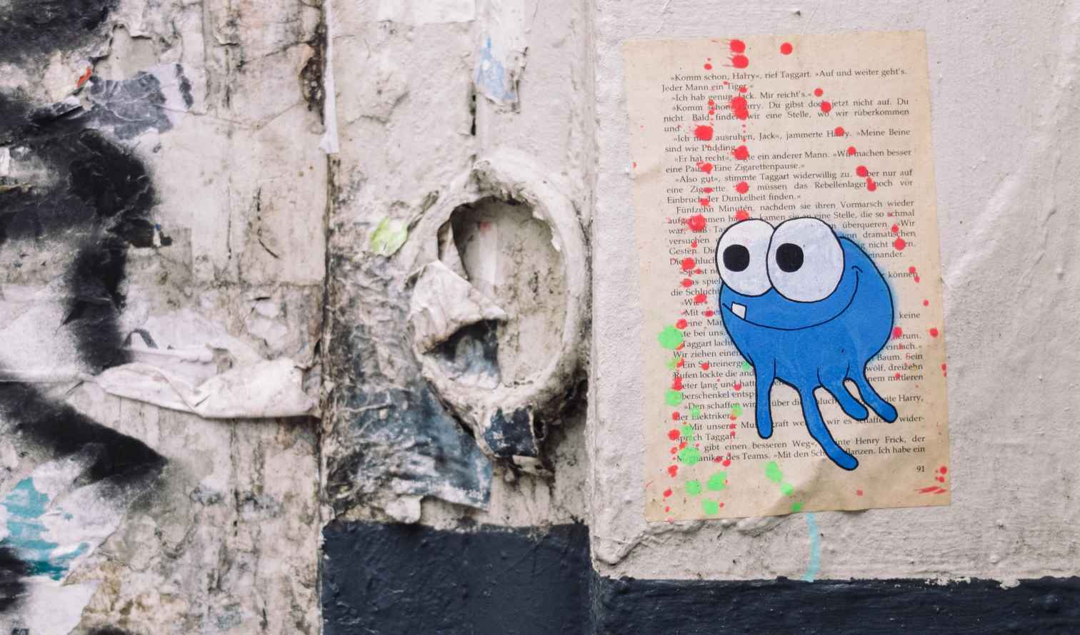 Street art featuring a blue cartoon character on a weathered wall.Hamburg