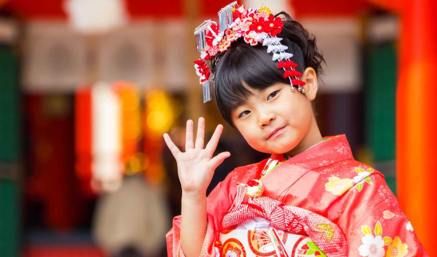 Girl in a red kimono at a Japanese temple entrance in Kobe