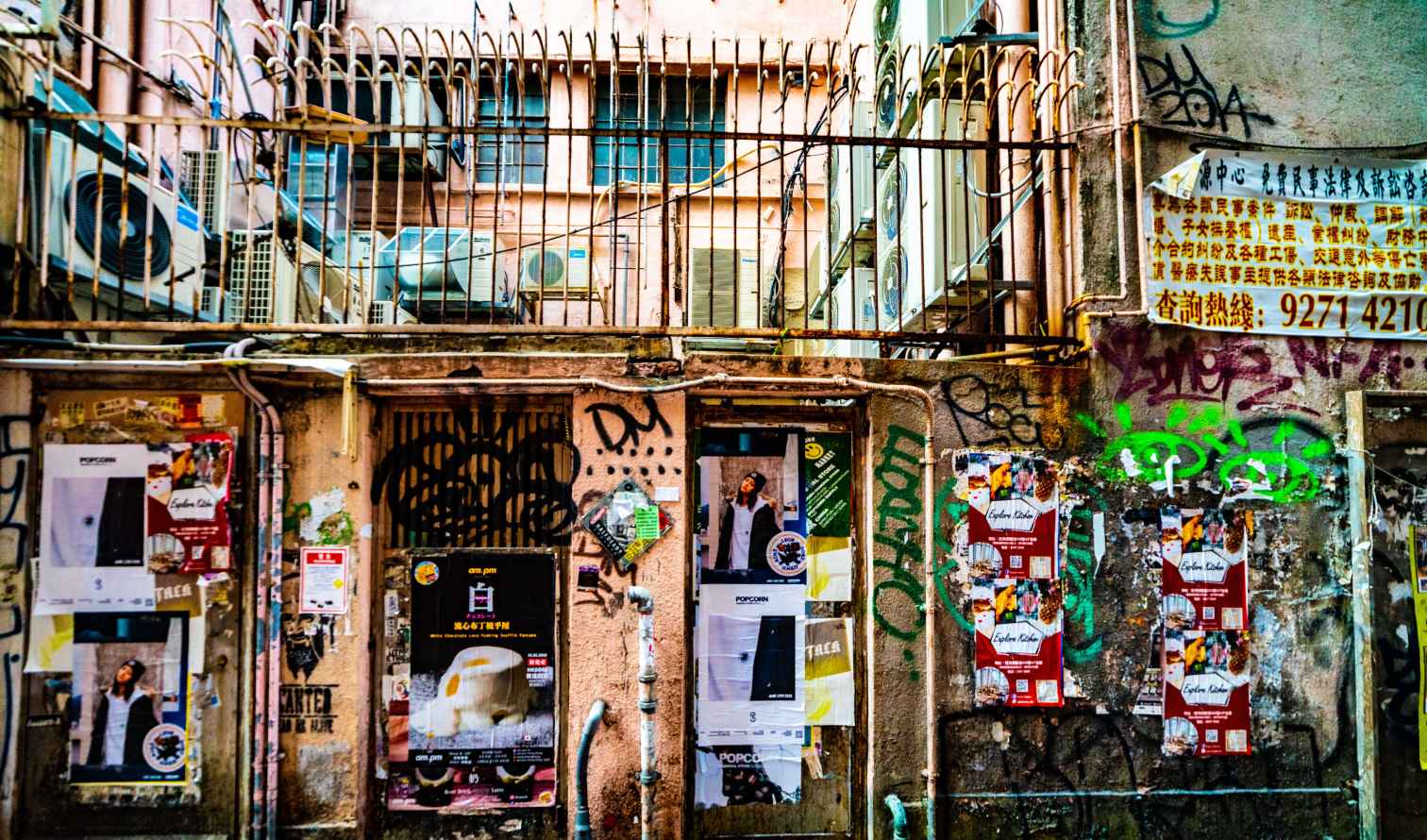 Graffiti-covered alley with air conditioners in Hong Kong.
