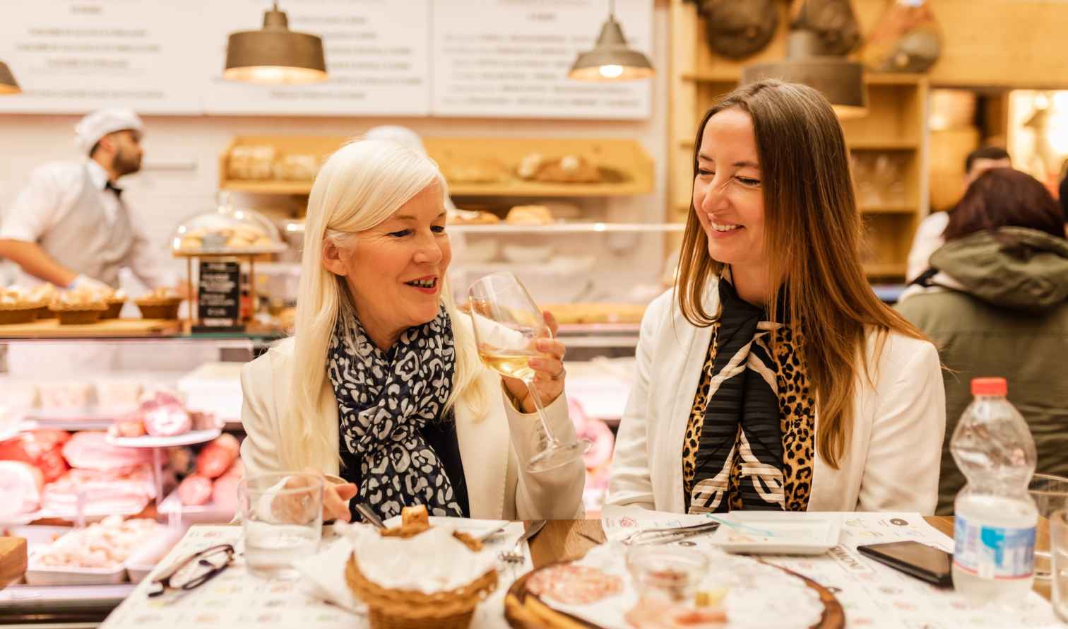 Two women sitting at a table in an Italian deli in Bologna