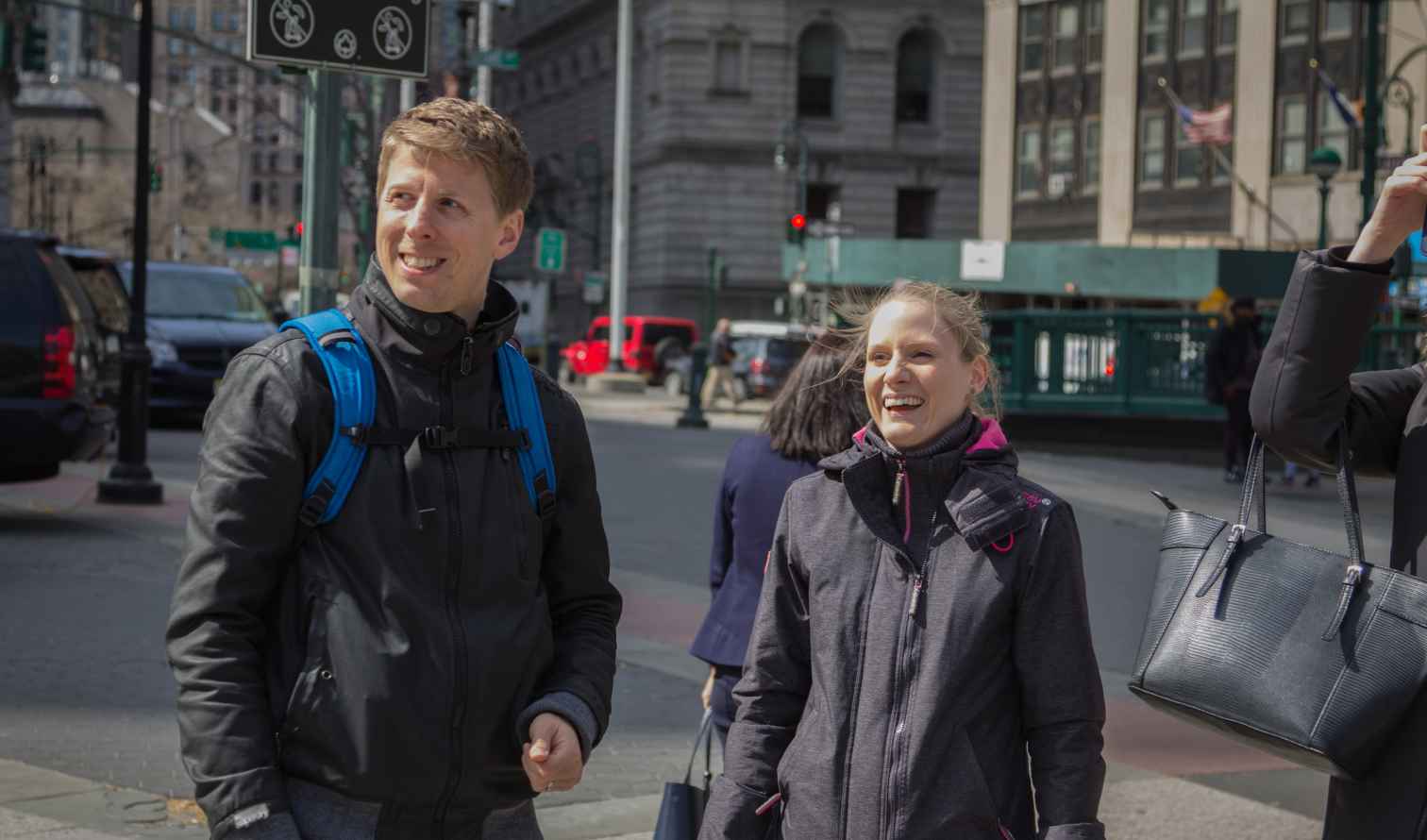 Two people standing near a street in New York City.