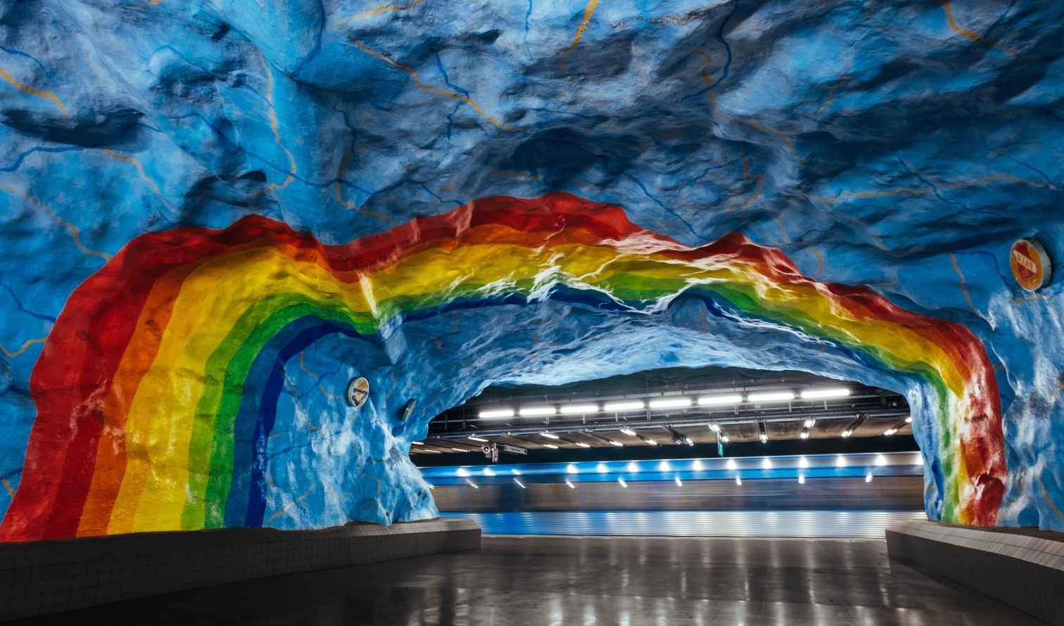 Inside Stadion metro station with colorful rainbow mural in Stockholm, Sweden.